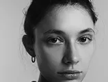 Black and white portrait of a woman with dark hair in an updo, looking directly at camera 